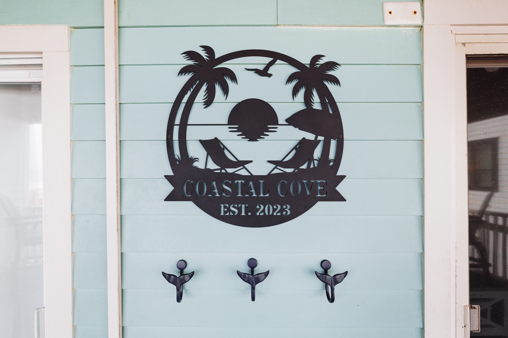 Coastal Cove established 2023 welcomes guests with tropical charm and beach-inspired design featuring palm trees and sunset imagery.