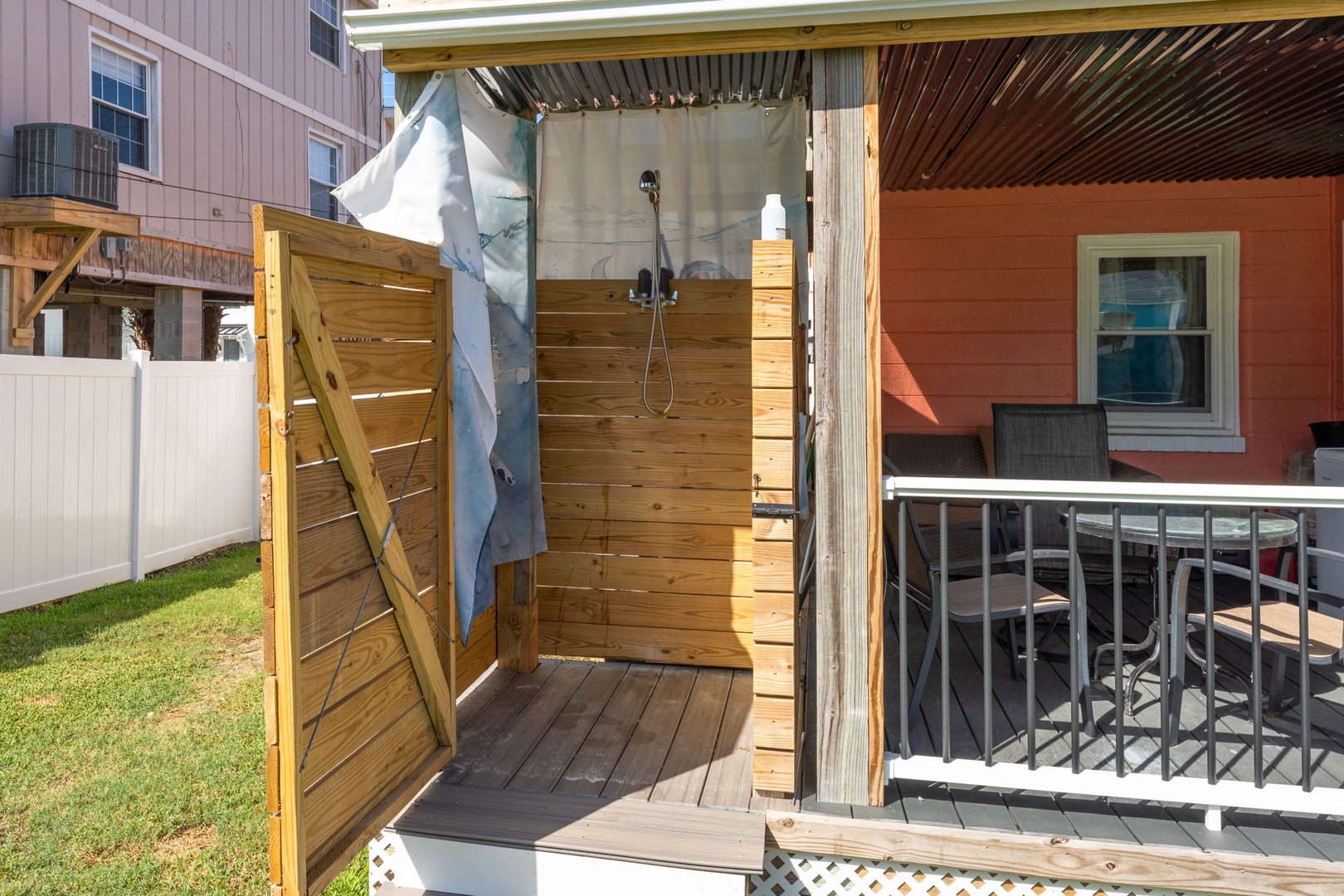 Rinse off salt and sand in your private outdoor shower, featuring natural wood privacy walls and refreshing open-air design.