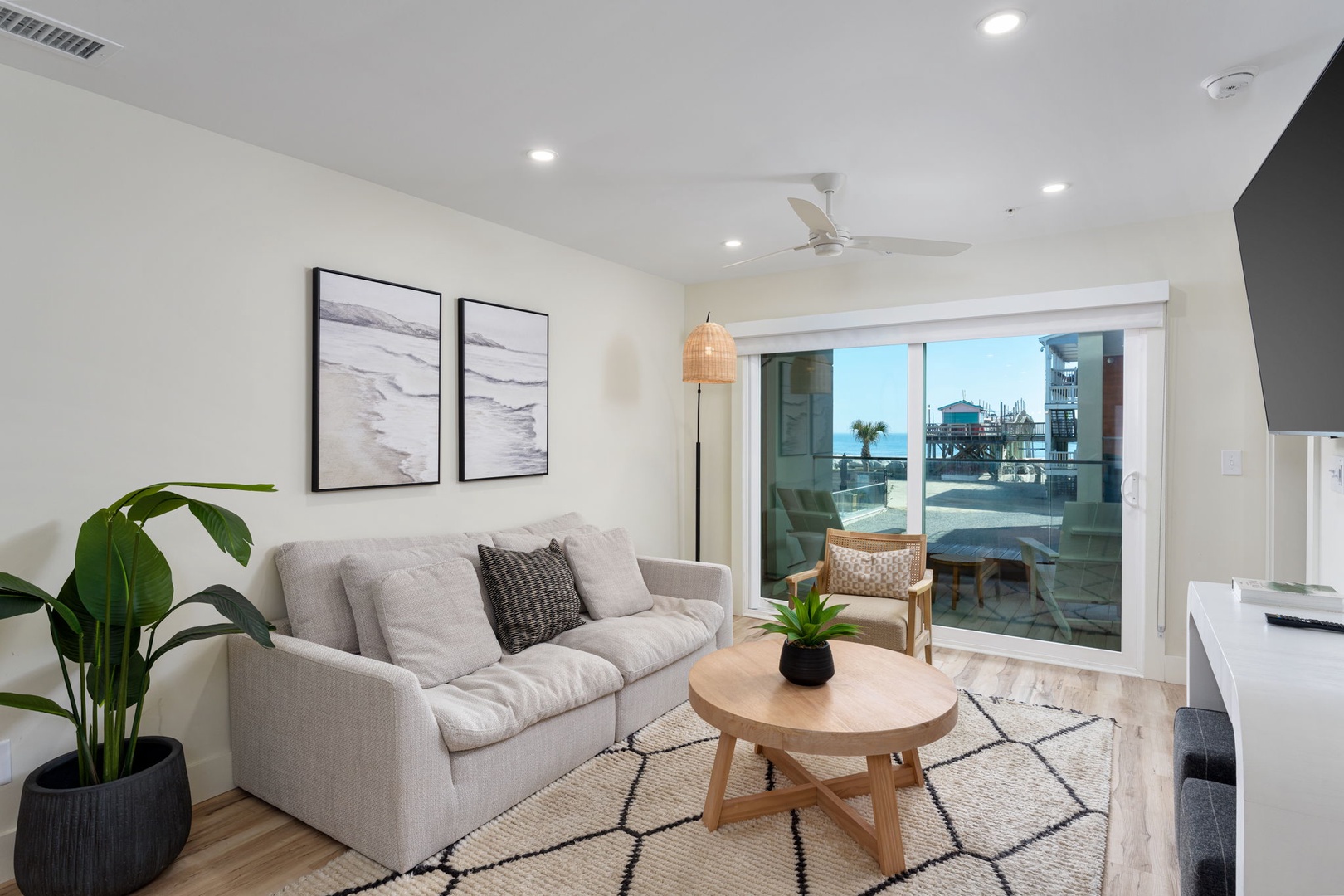 Unwind in your stylish living room with plush seating and floor-to-ceiling windows revealing stunning coastal views.