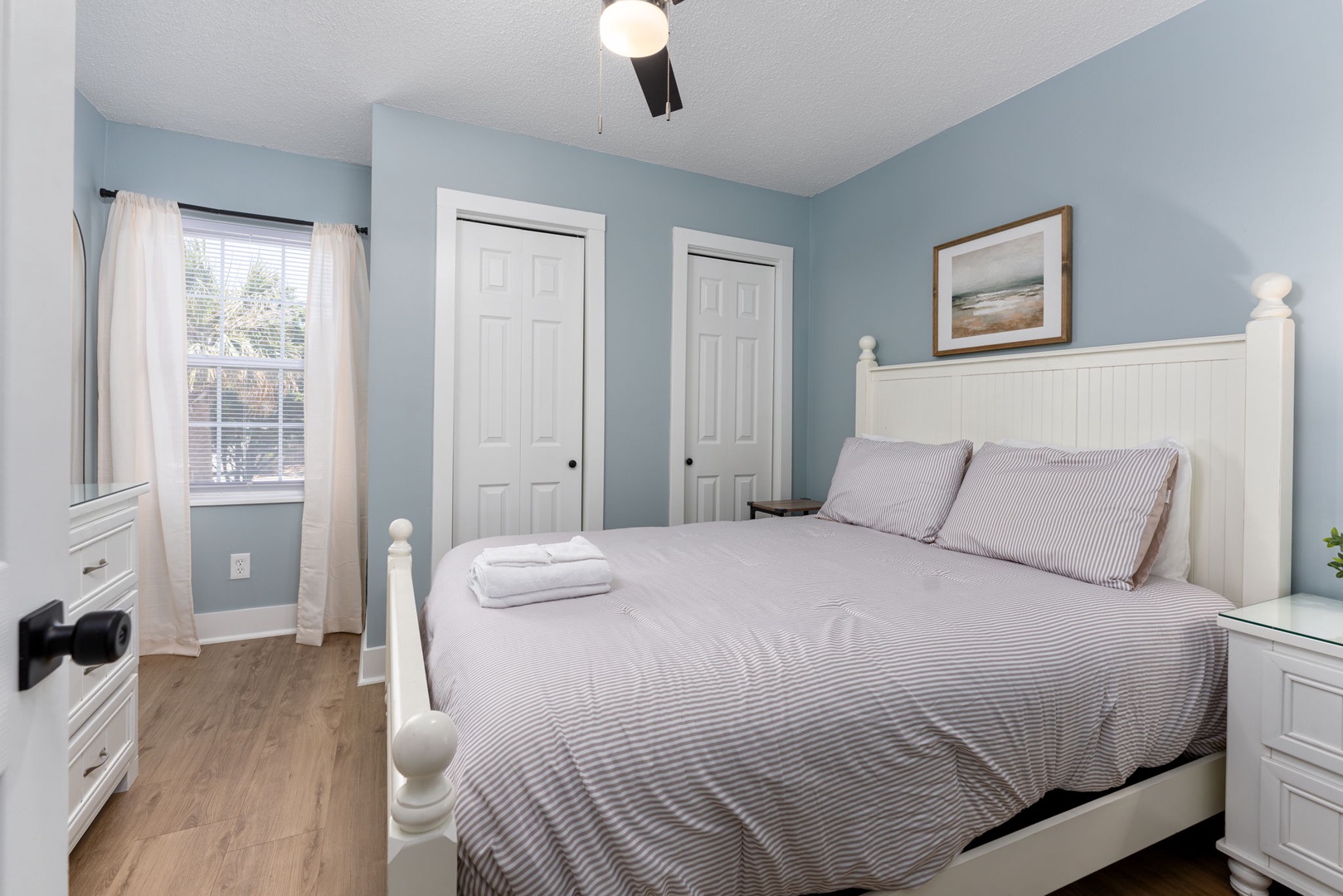 Sink into a cloud-soft bed surrounded by calming blue walls and cheerful morning light. Fresh towels await, promising a peaceful retreat after your daily adventures.