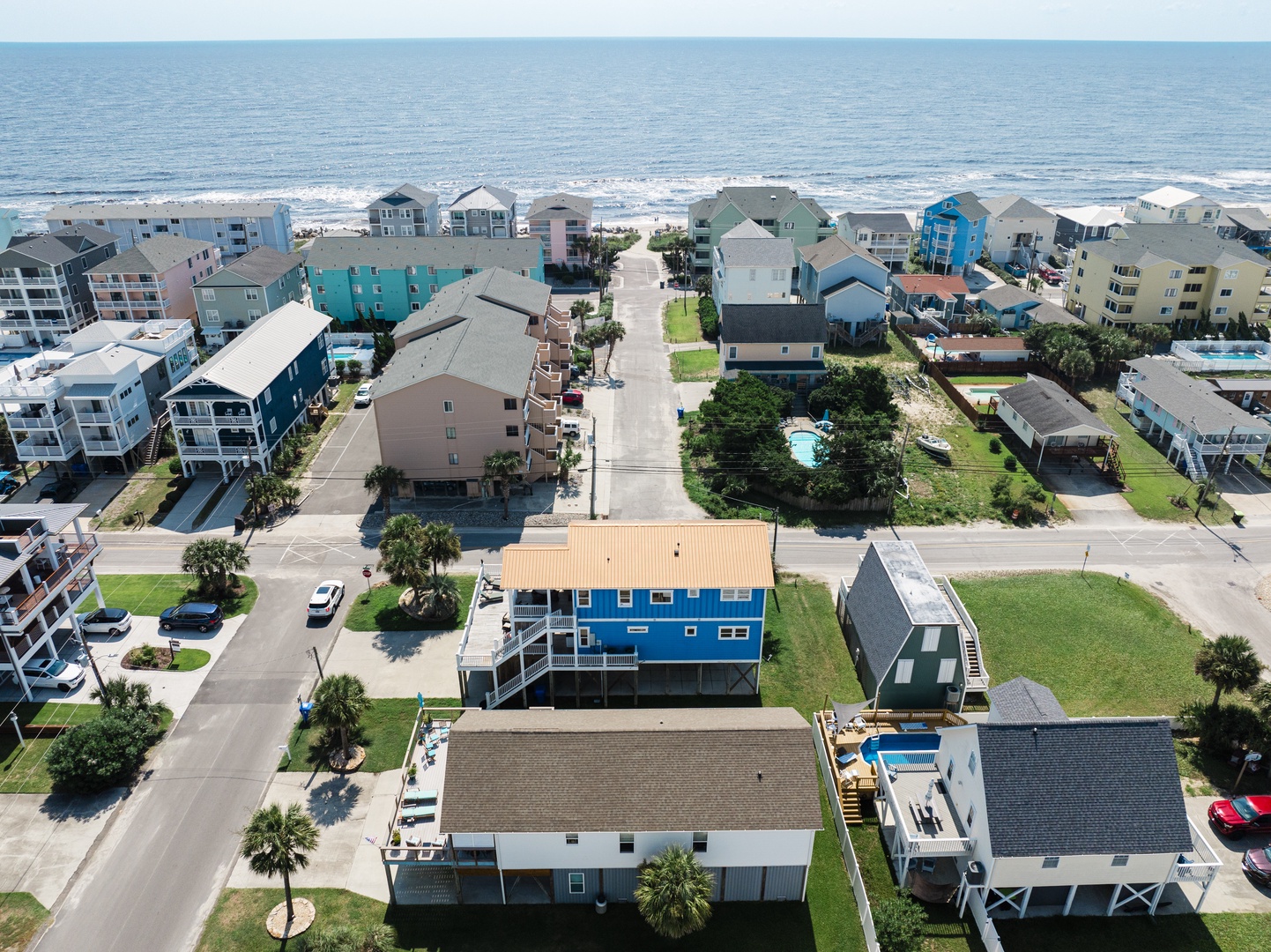 Charming coastal neighborhood with colorful beach houses just steps from pristine sandy shores and rolling ocean waves.