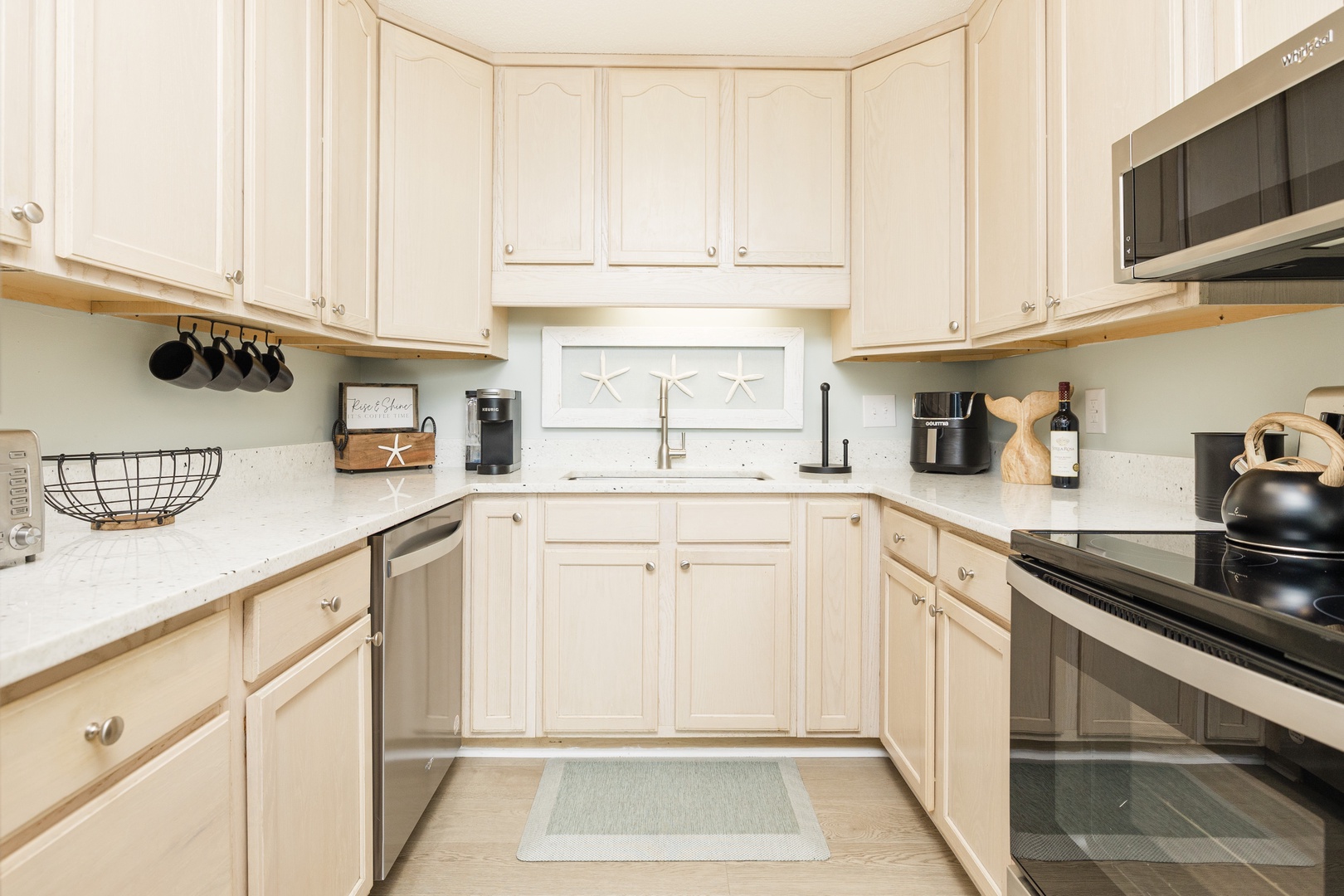 Your fully-equipped kitchen invites culinary adventures with crisp white cabinetry, granite countertops, and thoughtful coastal touches that make cooking feel like home.