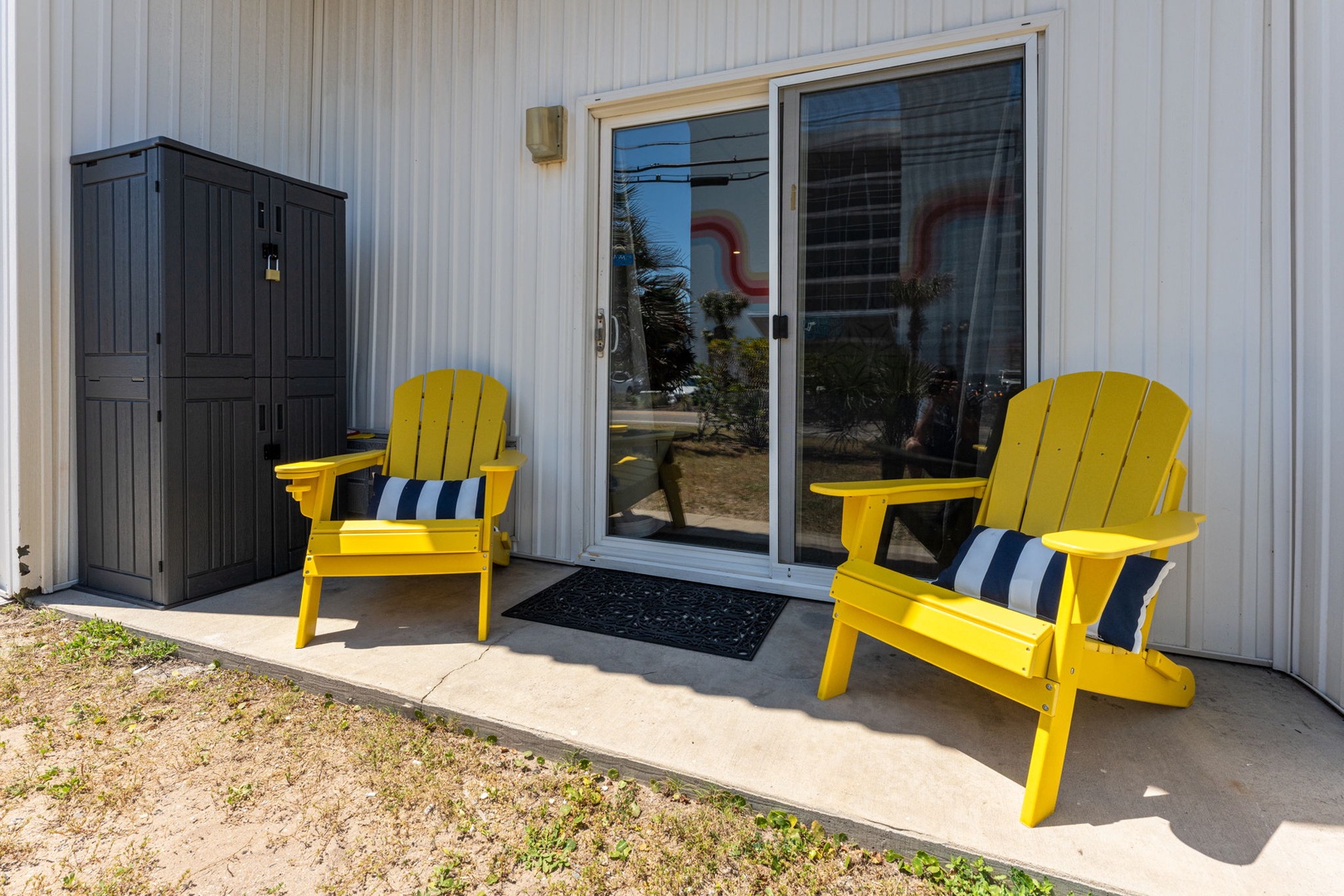 Settle into bright yellow Adirondack chairs on your private patio, where striped cushions invite you to unwind with morning coffee or evening relaxation.