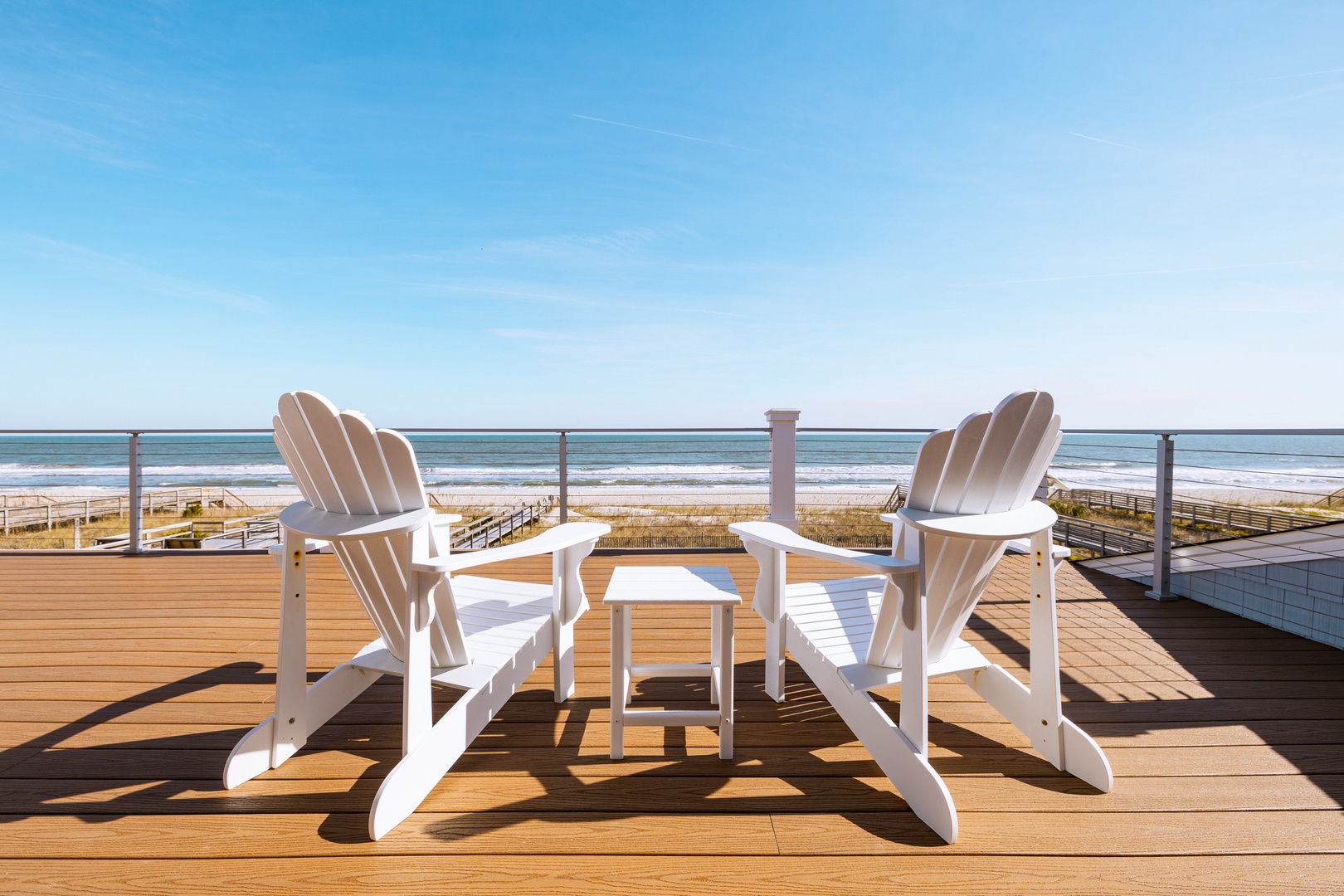 Sink into classic Adirondack chairs on your private deck, where ocean waves and endless blue skies create the perfect backdrop for morning coffee or sunset cocktails.
