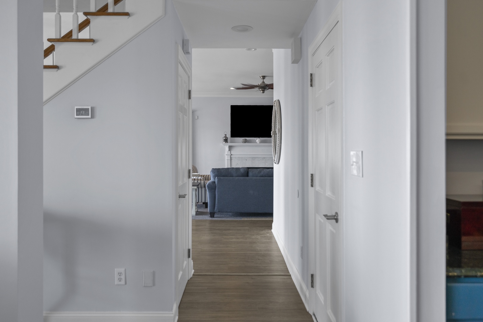 Step into your bright, modern hallway where sleek design meets comfort—with glimpses of the cozy living area ahead.