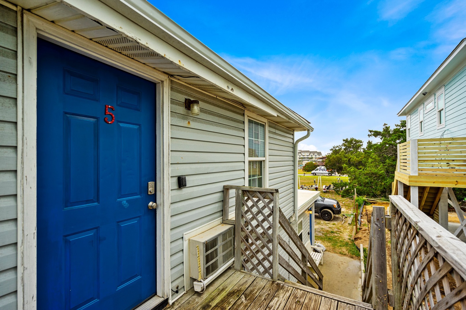 Welcome to your coastal retreat! The bright blue door opens to your beachside getaway, complete with AC comfort and charming neighborhood views.