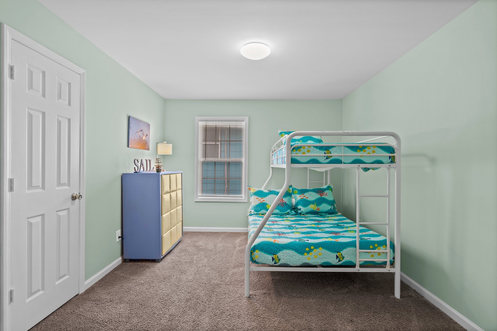 Your kids will love this cheerful bunk room with ocean-themed bedding and plenty of space to play and rest.