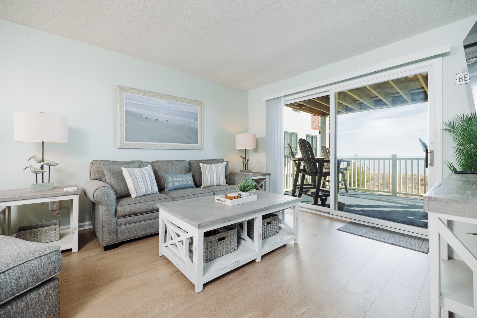 Sink into soft coastal comfort in your bright living room, where ocean breezes flow through open balcony doors to your private deck.