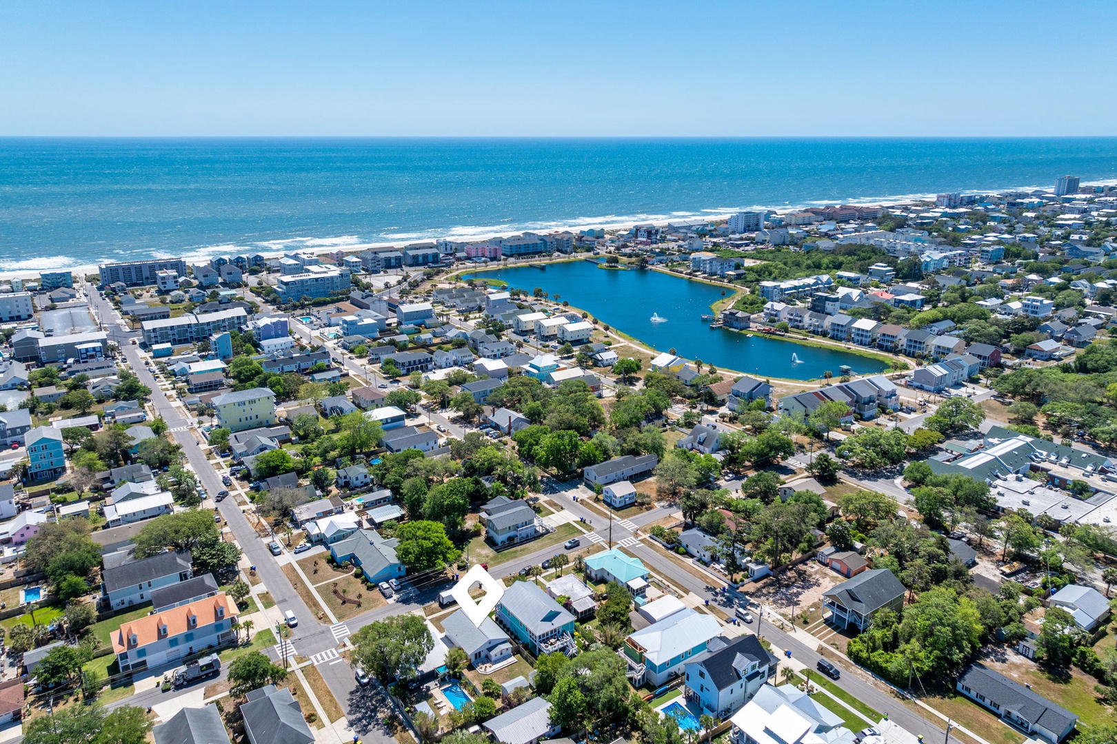 Stunning aerial view reveals a coastal community with pristine beaches, tranquil lagoon, and charming residential neighborhoods perfectly positioned near the ocean.
