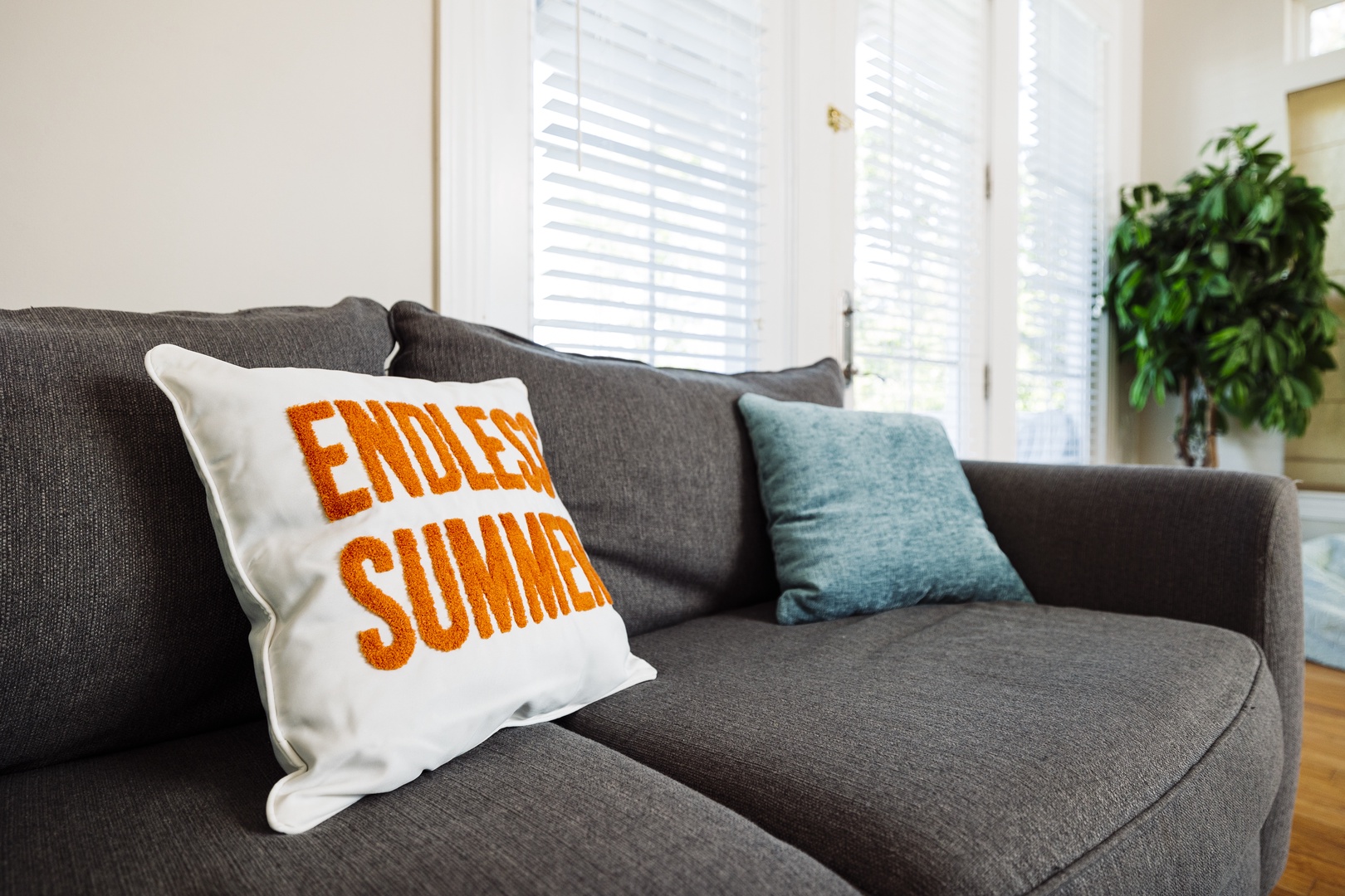 Sink into this plush sofa where cheerful pillows and natural light create your perfect spot for morning coffee or evening relaxation.