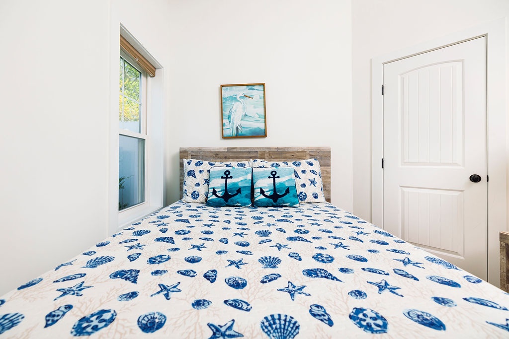 Your coastal-themed bedroom awaits with nautical bedding and peaceful artwork, creating a serene seaside retreat for restful nights.