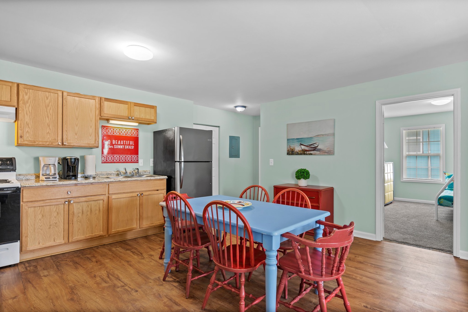 Your cheerful kitchen and dining space features warm wood floors, granite counters, and a charming blue table where you'll gather for memorable meals together.