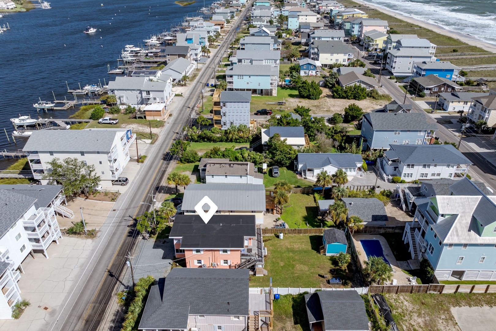 Aerial view of coastal neighborhood with marina access and beachfront location.