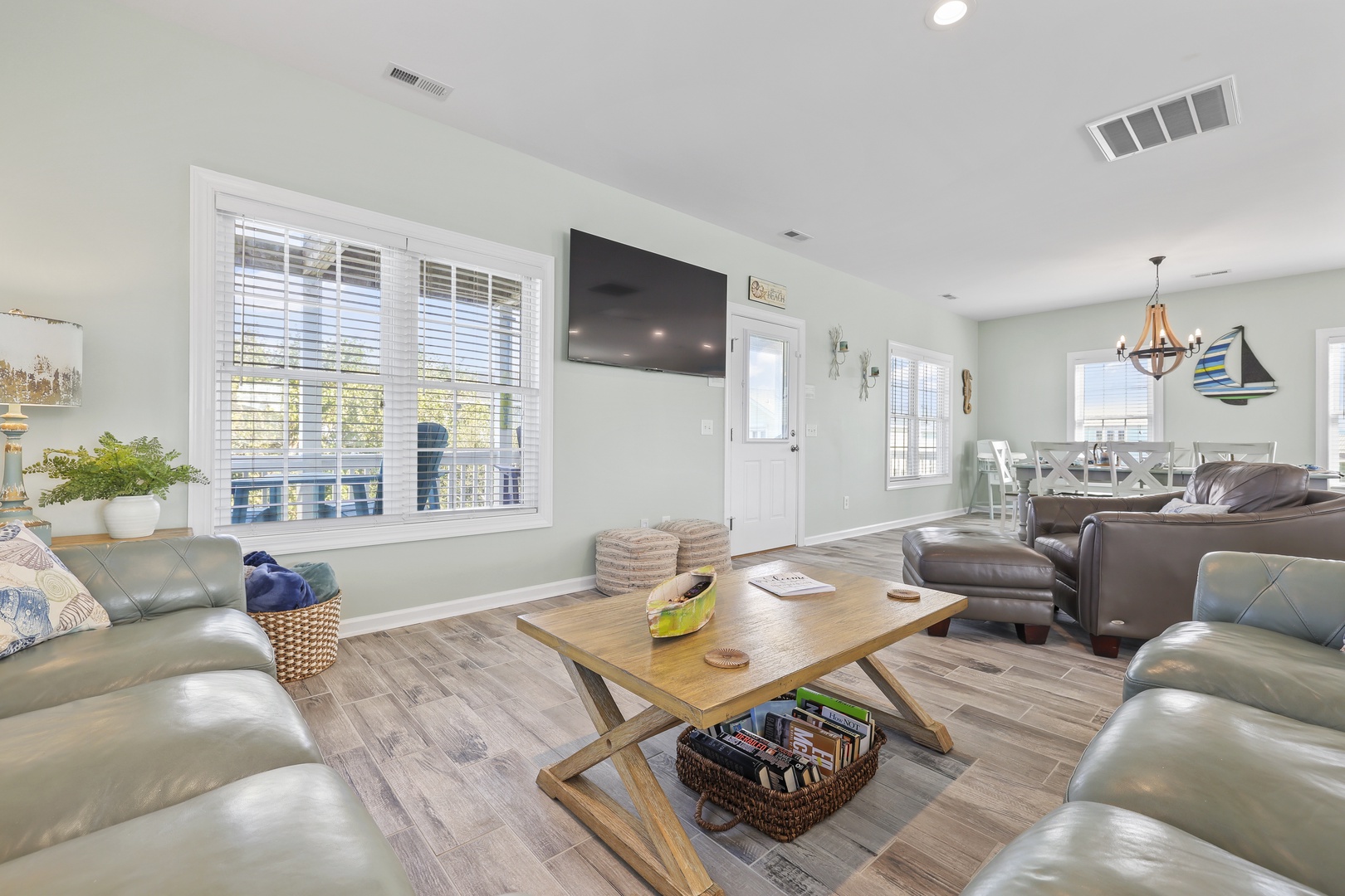 Stretch out in this spacious living room where coastal touches meet comfortable seating. Relax on plush leather sofas, catch your favorite show on the wall-mounted TV, and enjoy the natural light streaming through large windows.