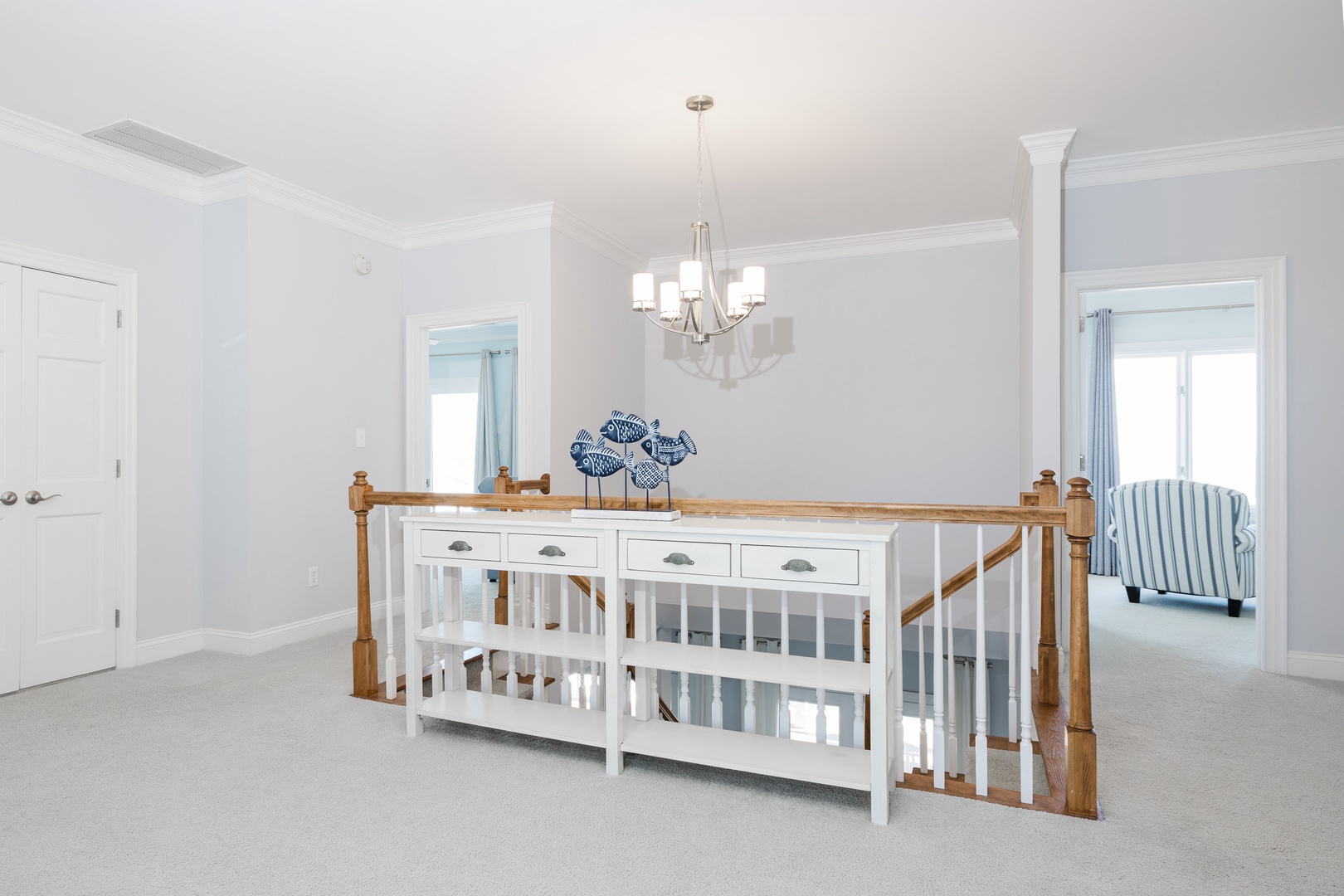 Light-filled upstairs landing offers peaceful retreat space with elegant coastal touches and comfortable seating nook for your quiet moments.