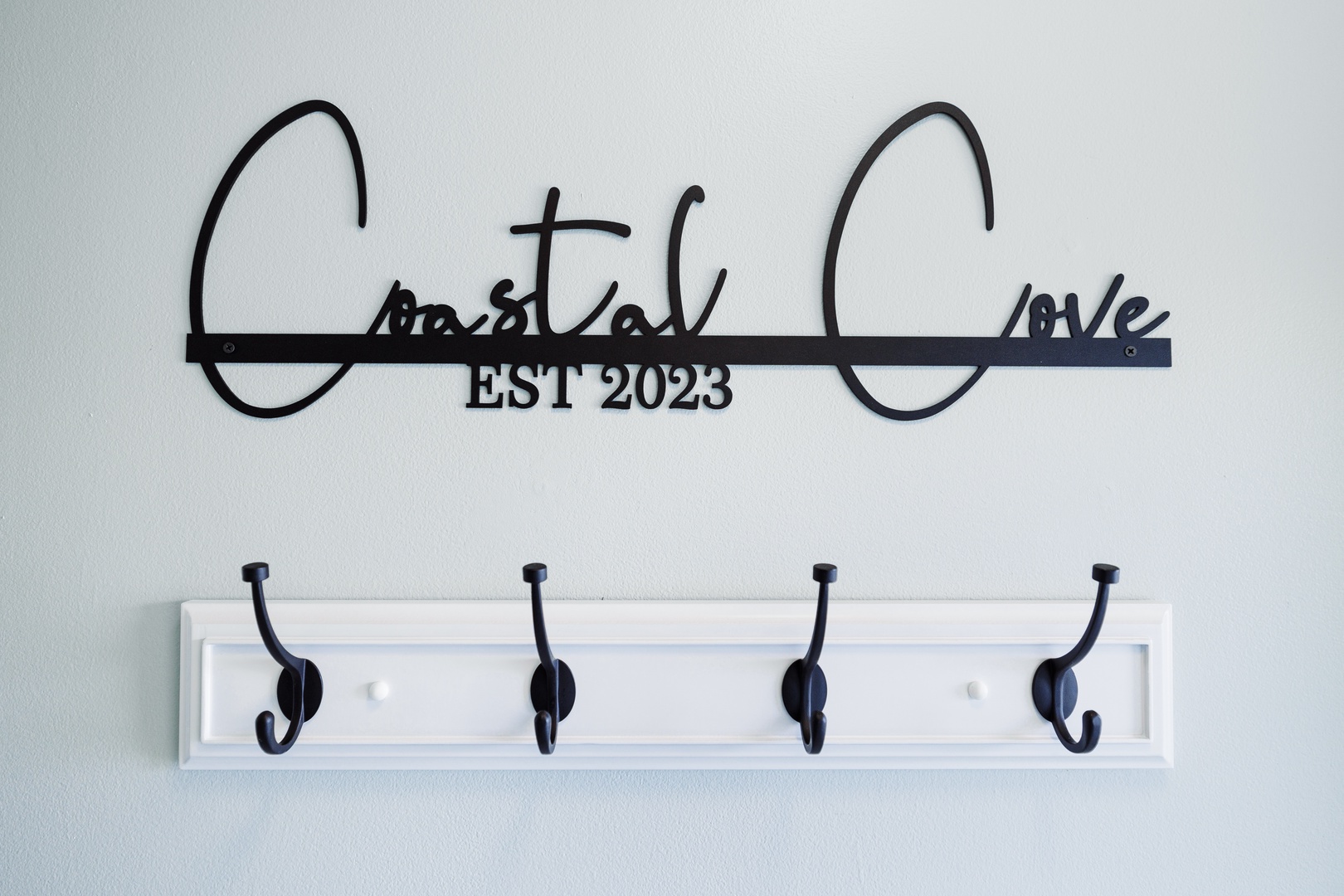 Keep your belongings organized with this charming coat rack and decorative coastal love sign—perfect for staying tidy during your getaway.