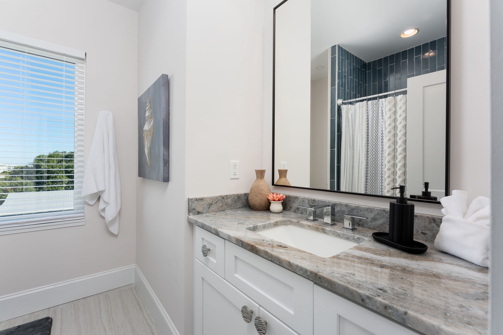 Unwind in your elegant bathroom featuring luxurious marble countertops and modern tile work that creates a spa-like retreat.