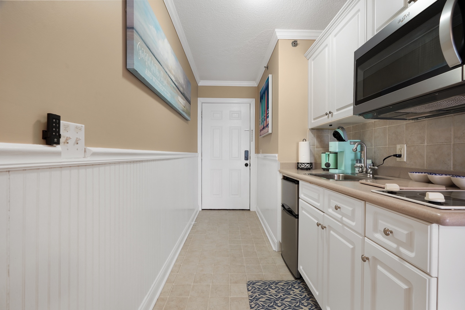 Your fully equipped galley kitchen features white cabinets, stainless appliances, and everything you need for home-cooked meals during your stay.