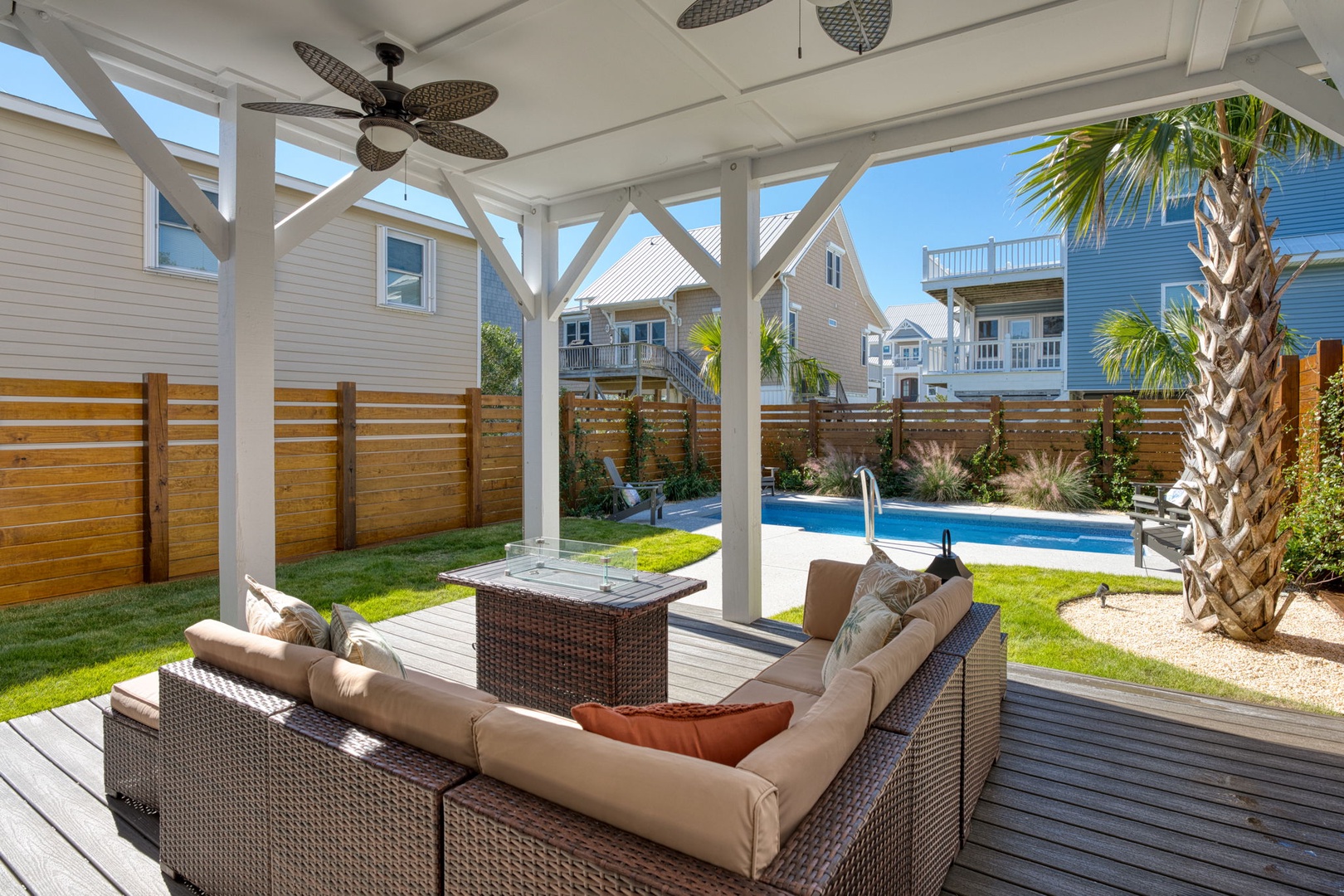Relax under your private pergola with poolside seating, ceiling fans, and tropical landscaping creating the perfect outdoor retreat.