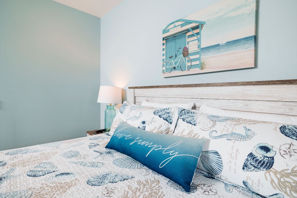 Your cozy coastal bedroom awaits with sea-themed linens and soothing blue tones that invite peaceful dreams after beach adventures.