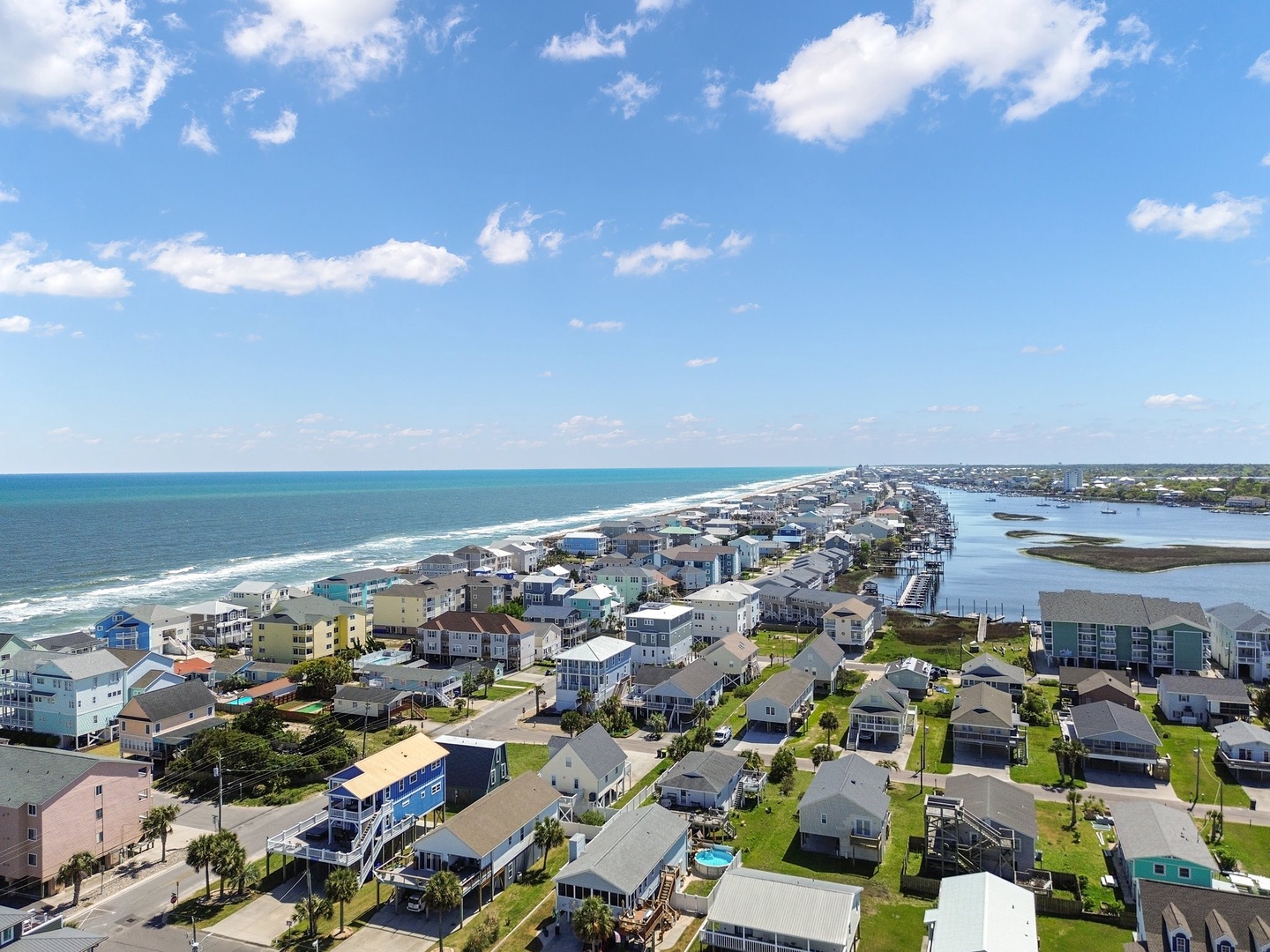 Stunning aerial view of a coastal community with oceanfront homes, sandy beaches, and peaceful waterways creating the perfect seaside getaway.