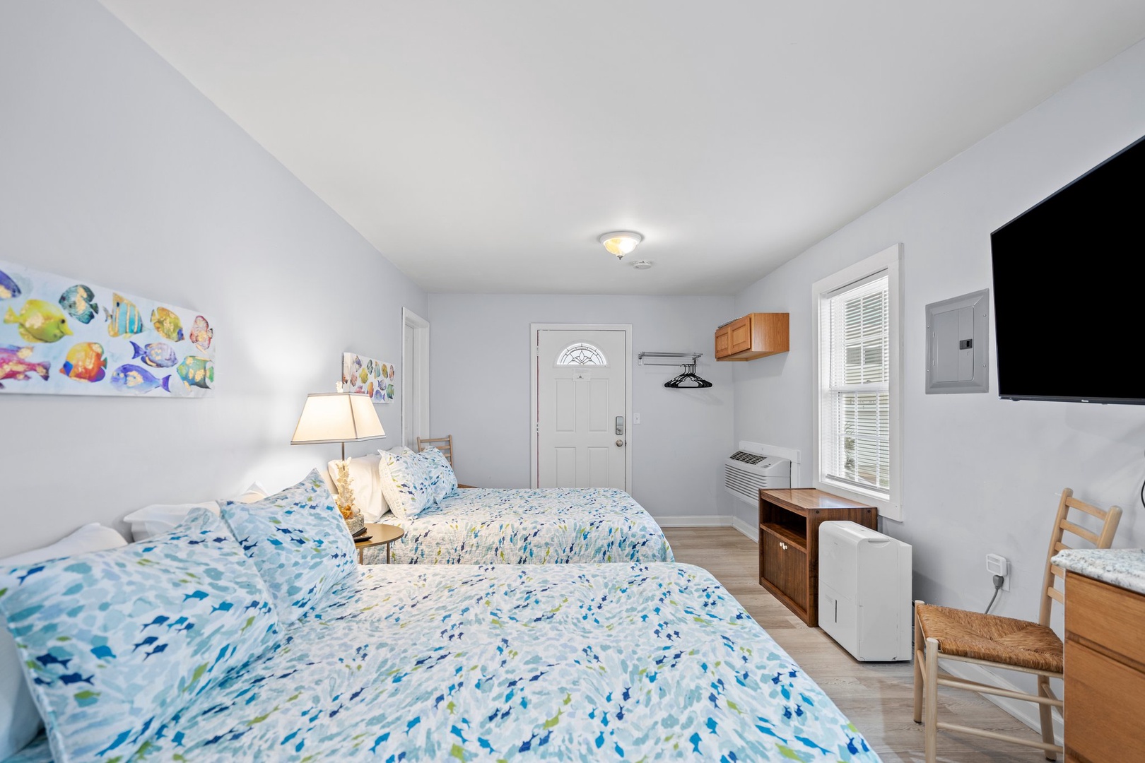 Settle into your peaceful twin bedroom where cheerful blue linens and ocean-themed artwork create a coastal retreat perfect for restful nights.
