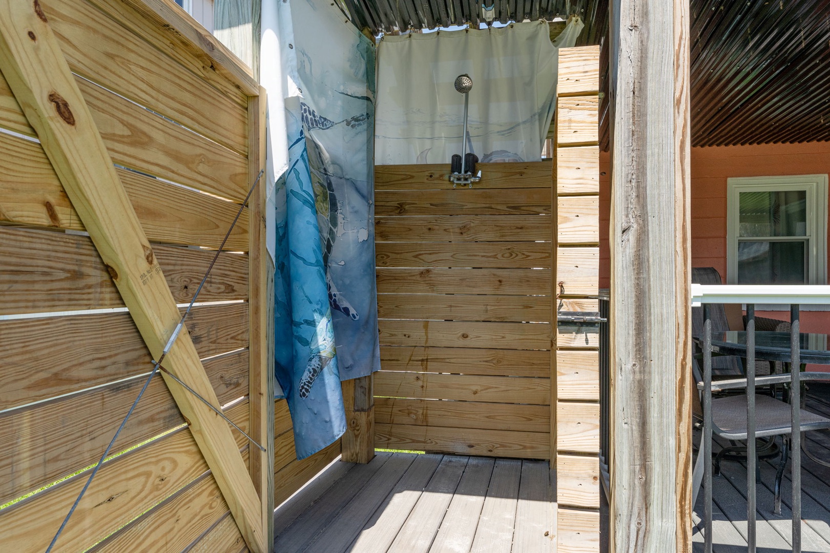 This private outdoor shower offers refreshing rinse-off convenience after beach days or poolside relaxation, surrounded by natural wood for a rustic coastal feel.