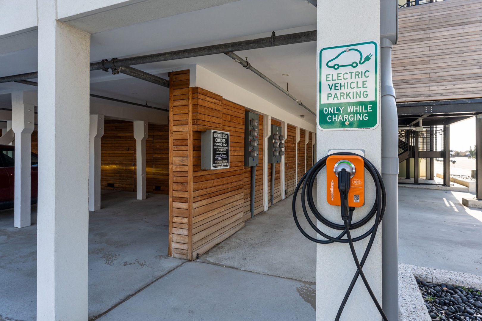 Electric vehicle charging station with dedicated parking at the property entrance.