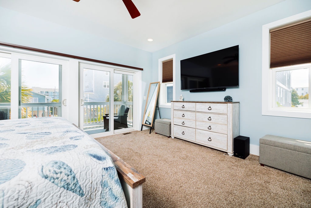 Your serene bedroom features comfortable bedding, entertainment center, and peaceful views through large windows with natural light streaming in.