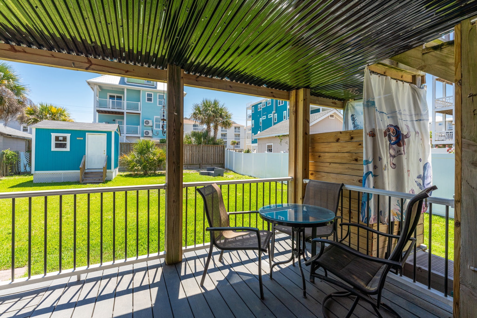 Relax on your private covered deck with a morning coffee or evening drink. Enjoy the shaded seating and peaceful lawn views in this coastal neighborhood.