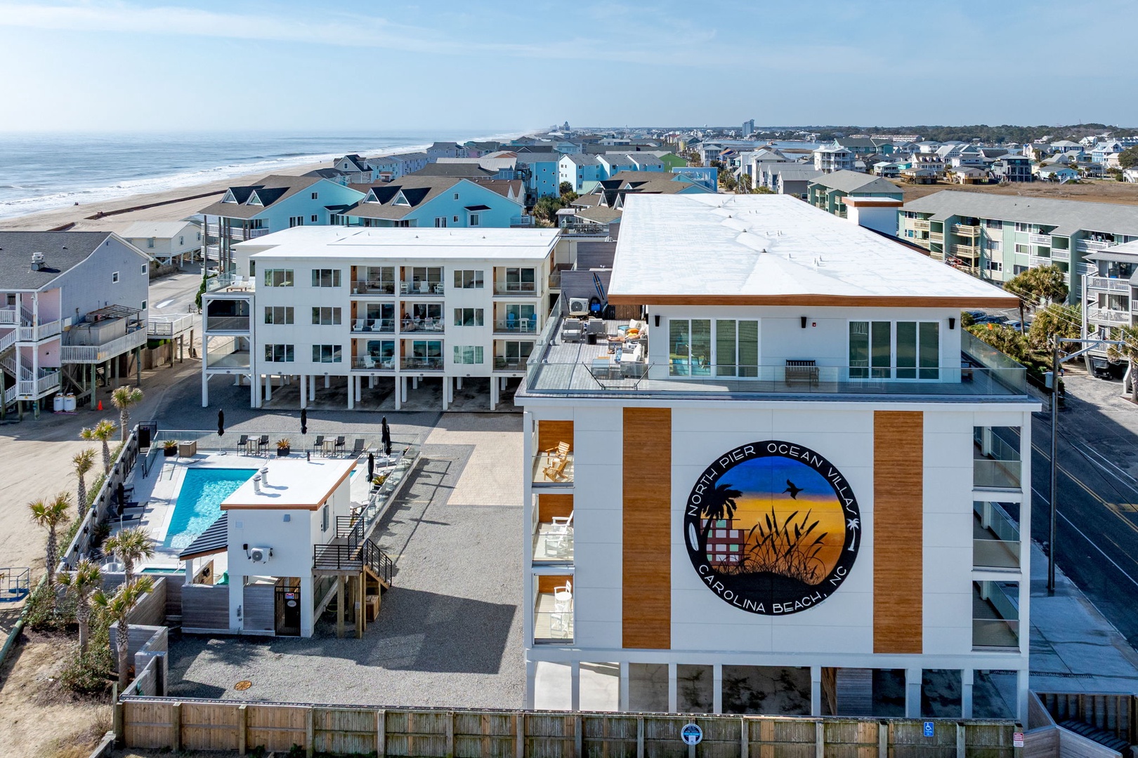 Modern beachfront property featuring swimming pool and rooftop amenities, located steps from Carolina Beach with easy ocean access.