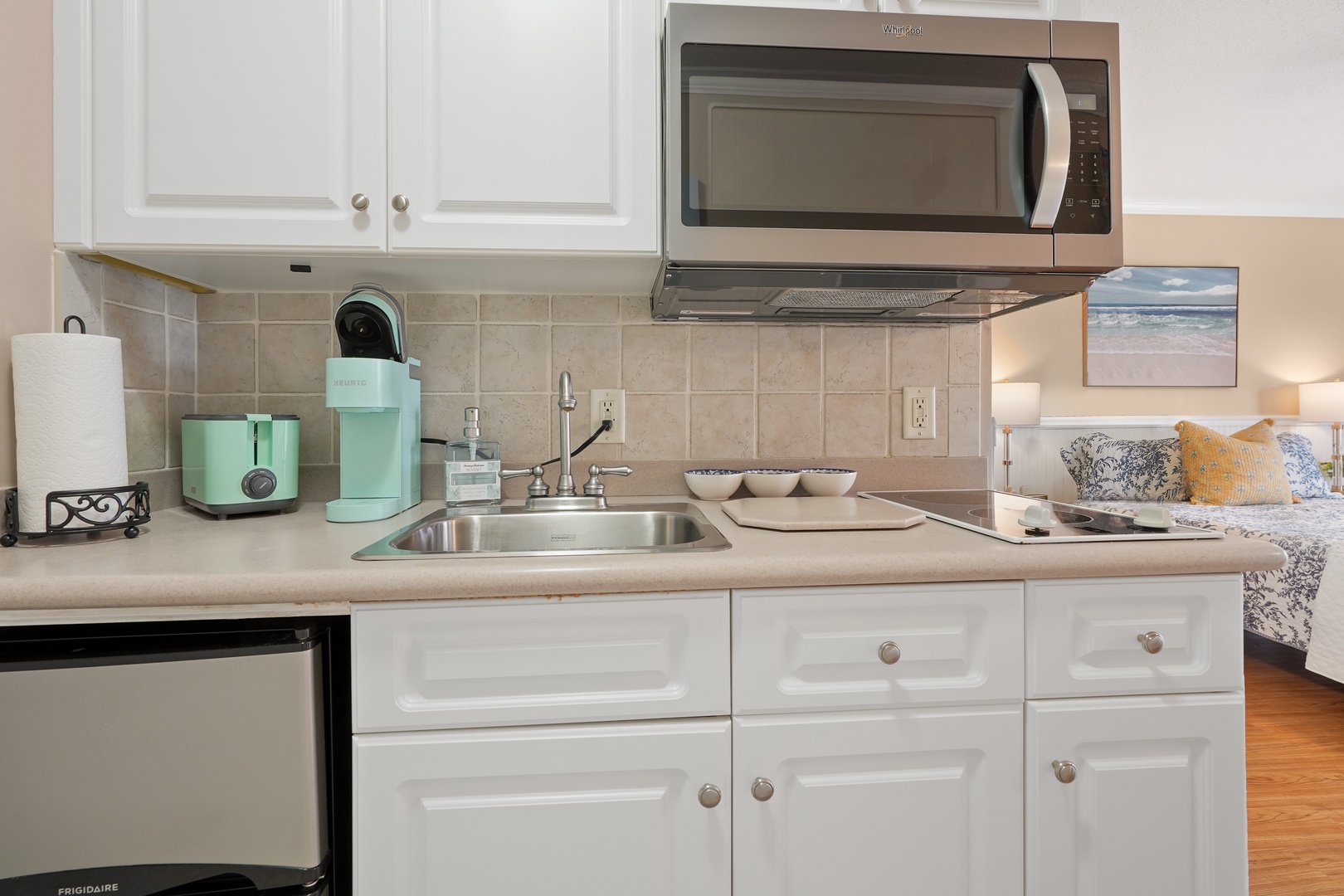 Your fully equipped kitchen makes meal prep a breeze with modern appliances and charming mint-green accents.