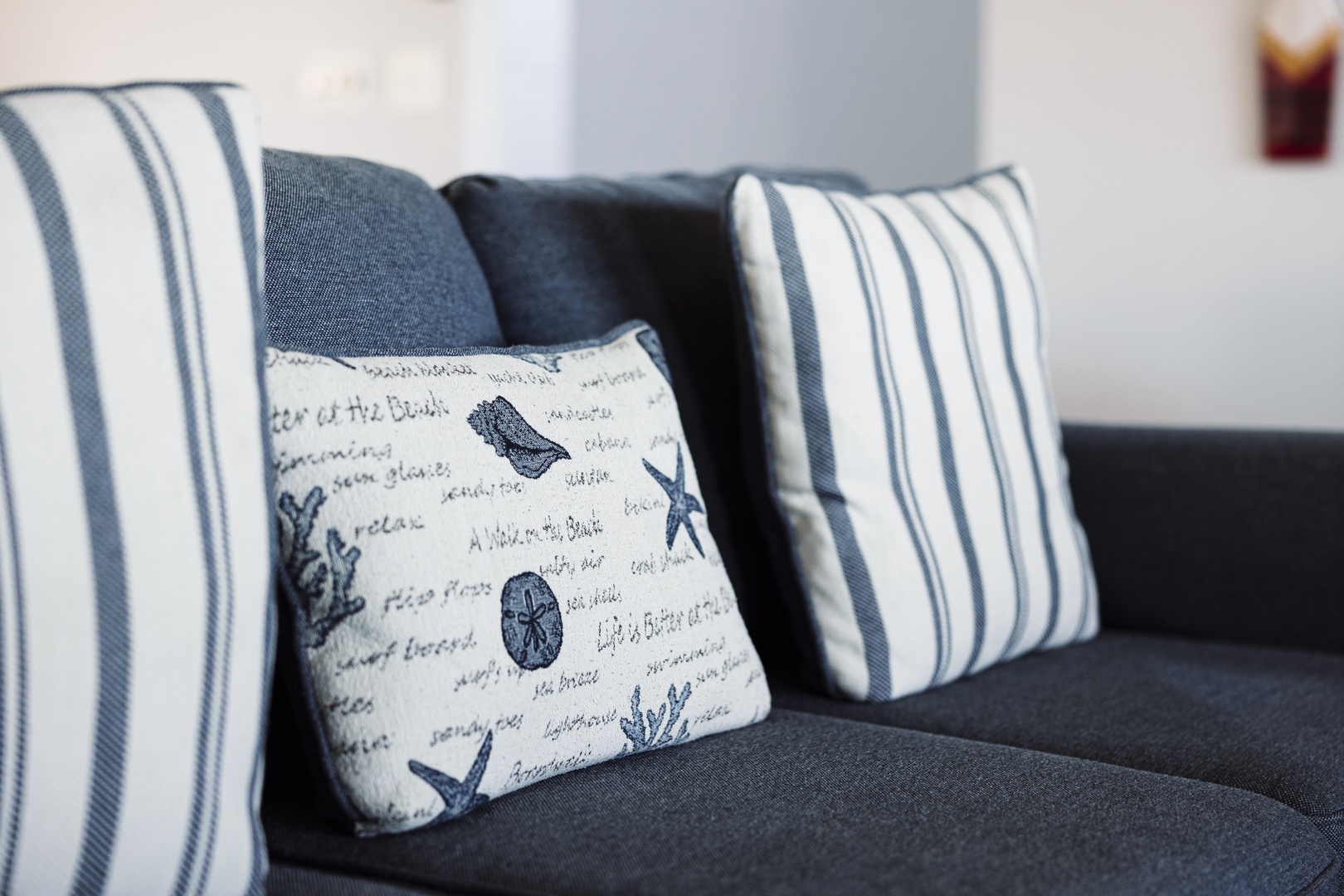 Sink into plush navy cushions adorned with charming nautical pillows, where crisp stripes meet seaside motifs for your perfect relaxation retreat.