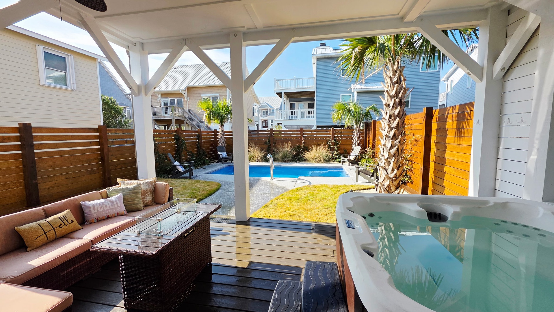 Unwind in your private hot tub while overlooking the sparkling pool and tropical palms in this serene covered patio retreat.