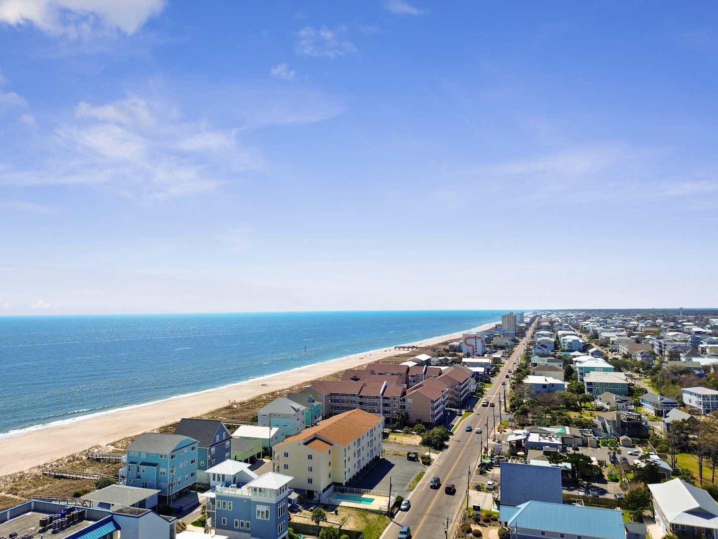 Aerial view showcasing the stunning coastal location with pristine beaches and charming beachfront community stretching along the shoreline.