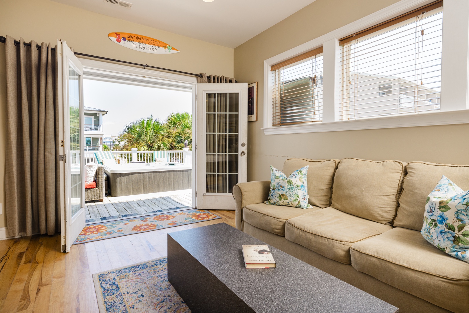 Relax in your bright coastal living room with tropical-print pillows and French doors opening to your private deck with hot tub.