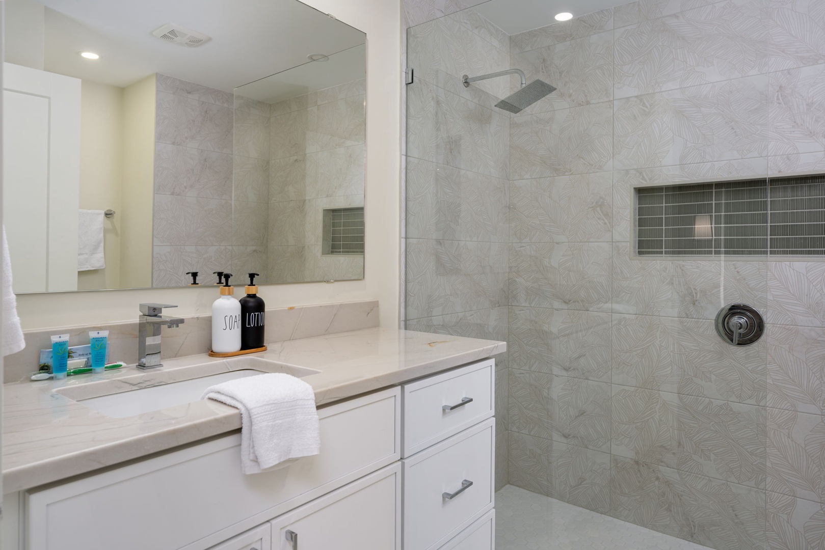 Your modern bathroom features a spacious walk-in shower with rainfall head and elegant vanity with premium amenities for your comfort.