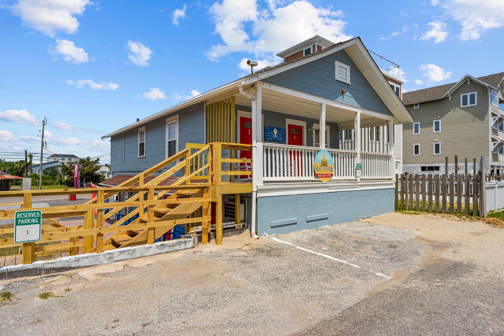 Charming coastal beach house featuring welcoming front porch and convenient reserved parking in peaceful residential neighborhood.