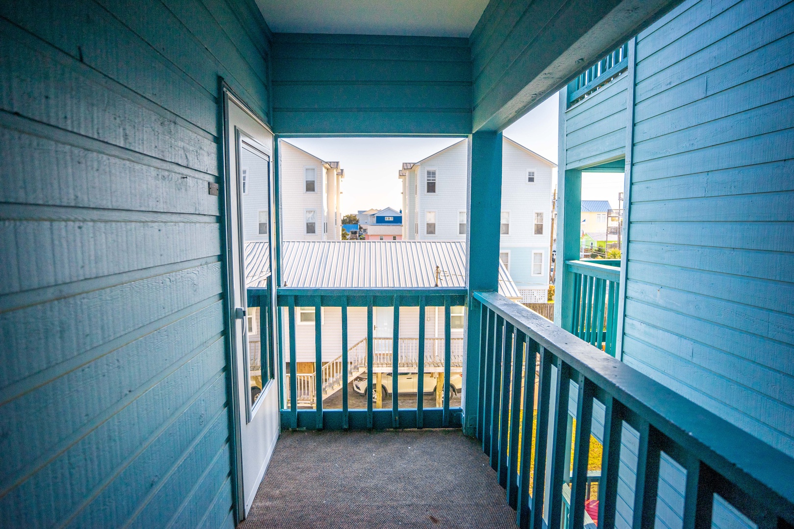 Step onto your private balcony and breathe in the fresh coastal air while enjoying views of colorful beach houses.
