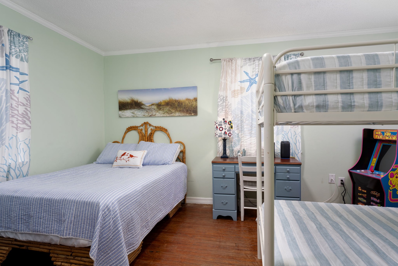 Your coastal-themed bedroom offers comfort for all ages with a cozy double bed and bunk bed, plus arcade fun for memorable evenings together.