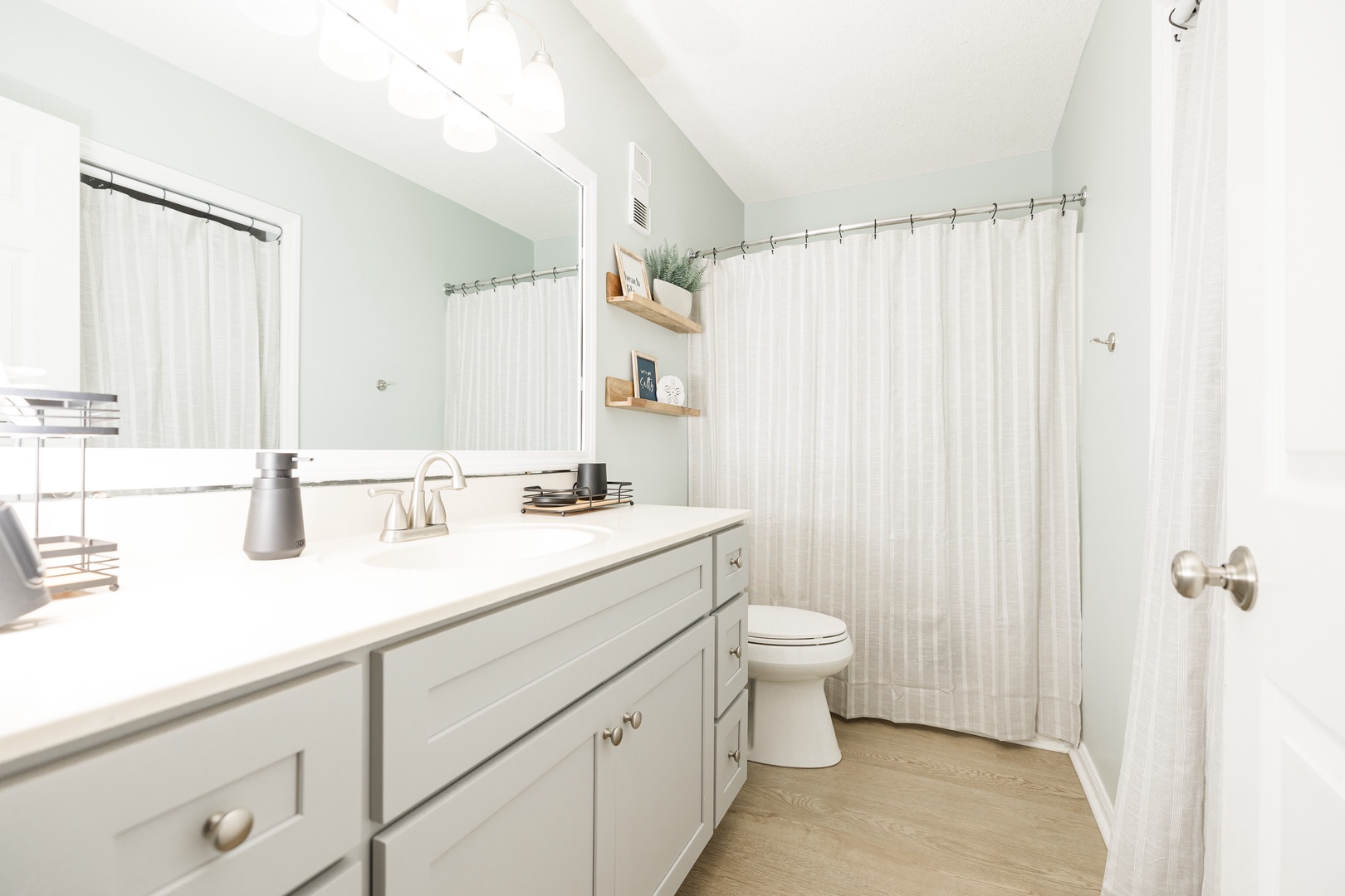 Step into your pristine bathroom sanctuary with crisp white finishes, generous counter space, and soft natural light from the window.