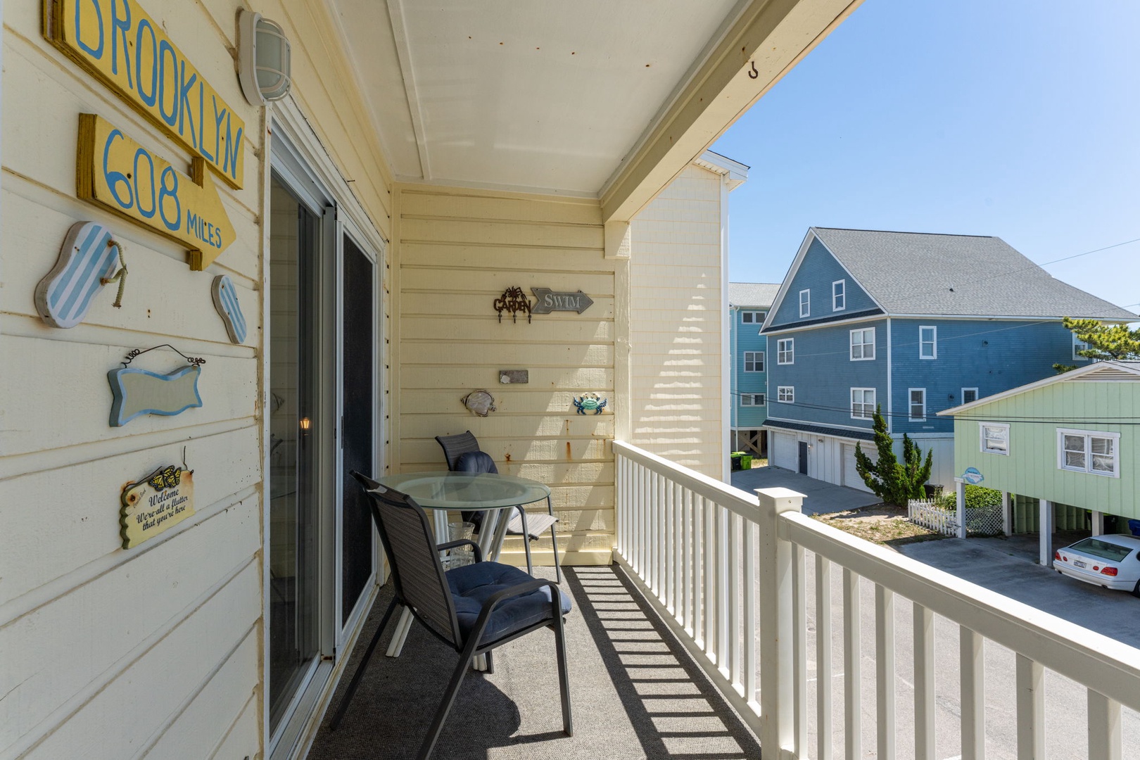Sip your morning coffee on this charming balcony with coastal decor and neighborhood views, featuring comfy seating for two and playful beachy touches.