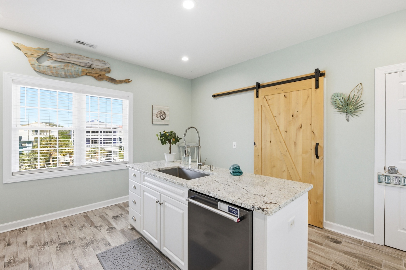 Your fully-equipped kitchen features granite countertops, modern appliances, and charming coastal touches, perfect for preparing fresh meals during your stay.