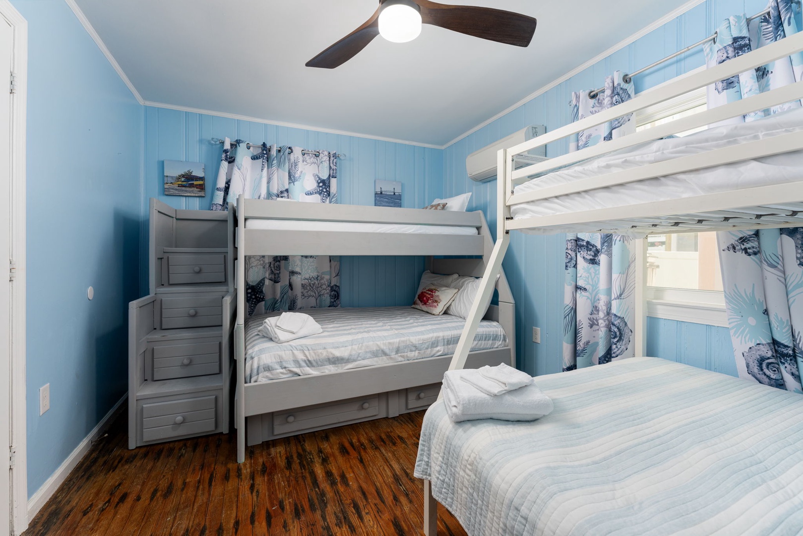 Slip into crisp linens and drift off under the gentle hum of your ceiling fan in this coastal-inspired bunk room, perfect for family memories.