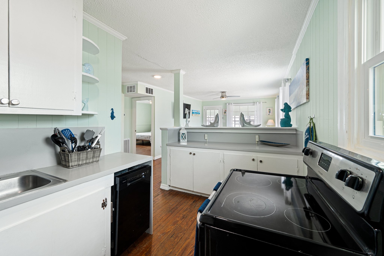 Your fully-equipped kitchen features white cabinetry, stainless steel appliances, and charming coastal touches that make meal preparation a delight.