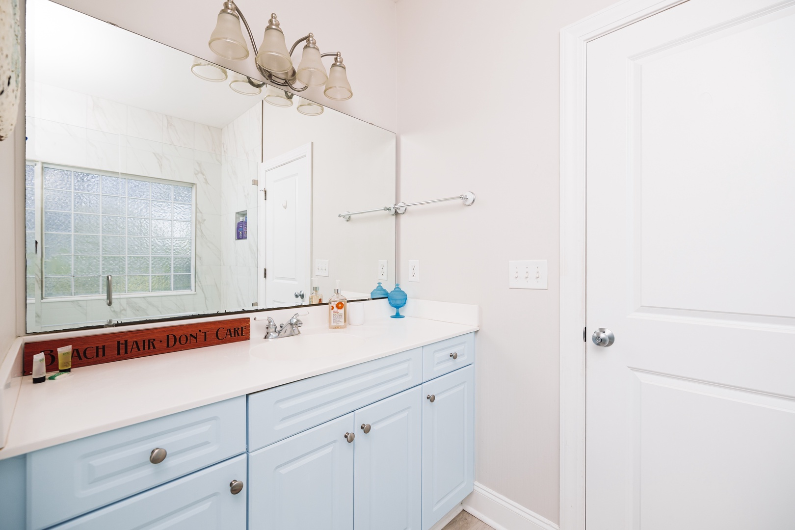 Your bright, coastal-themed bathroom features dual sinks, ample storage, and charming beachy touches that make your morning routine feel like a seaside retreat.