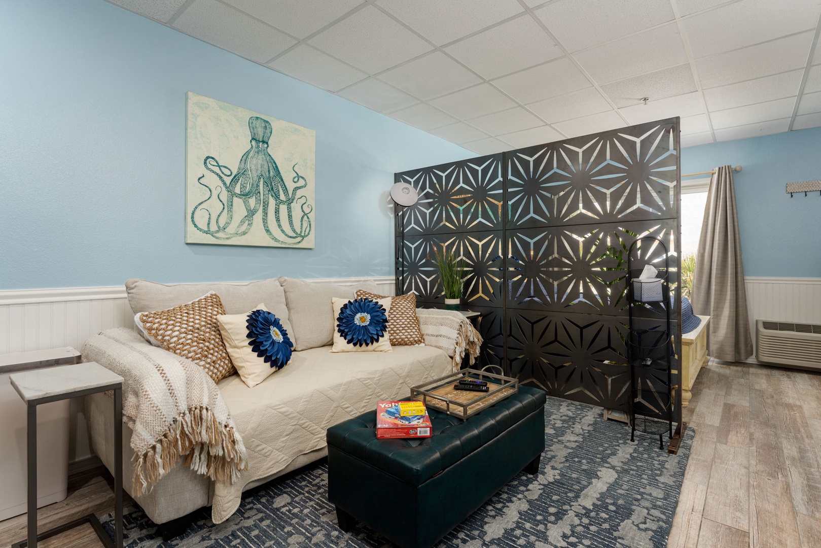 Relax in your coastal-themed living area with ocean artwork and cozy seating perfect for unwinding after beach days.