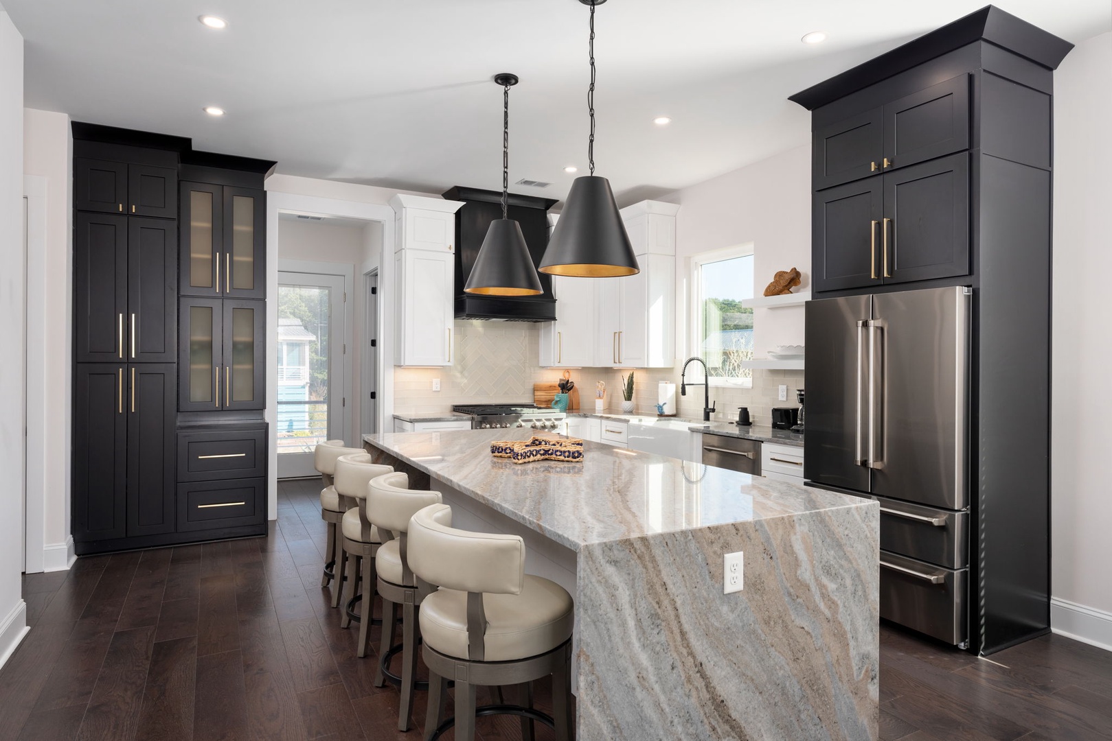 Your gourmet kitchen awaits with gleaming marble island, professional appliances, and elegant pendant lighting for memorable cooking experiences.