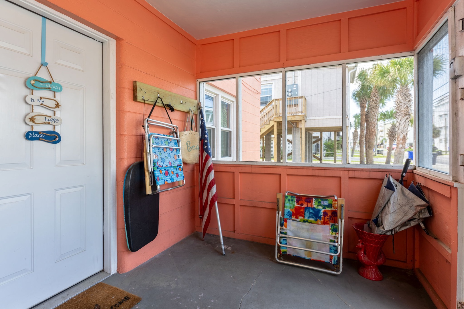This cheerful coral-hued enclosed porch is a perfect spot to hang beach gear and relax after a day in the sun. With space for essentials and a view of swaying palms, it makes coming and going feel like part of your coastal escape.