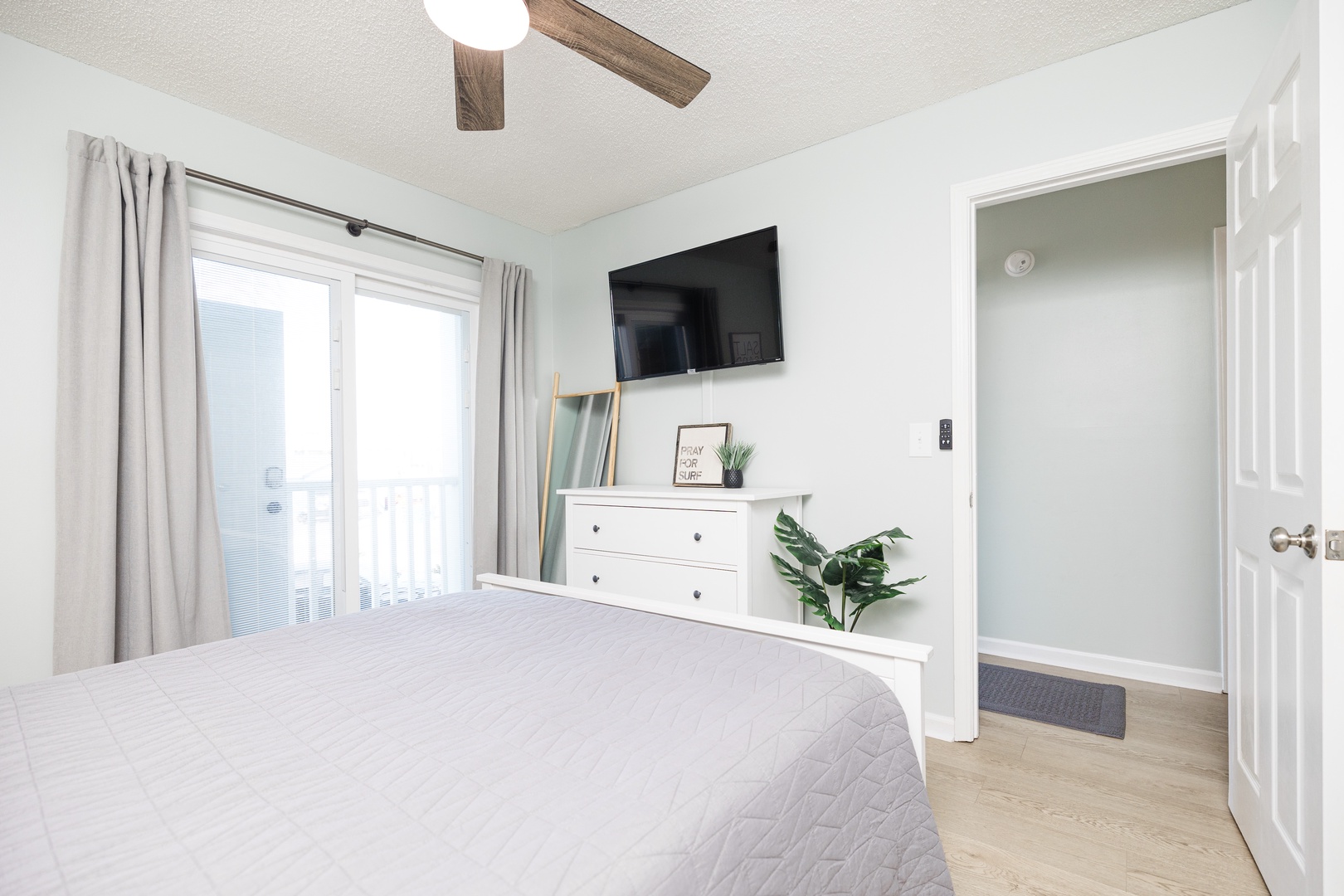 Wake up refreshed in your bright, airy bedroom with ceiling fan, smart TV, and peaceful balcony access for morning coffee.
